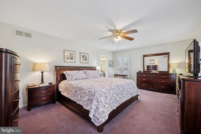 bedroom with visible vents, dark carpet, and a ceiling fan