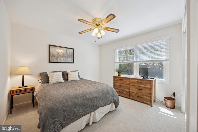 bedroom with ceiling fan, light carpet, and baseboards