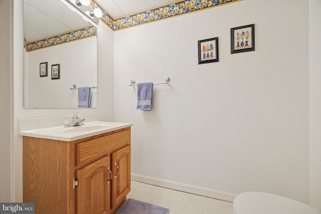half bath featuring baseboards, toilet, and vanity