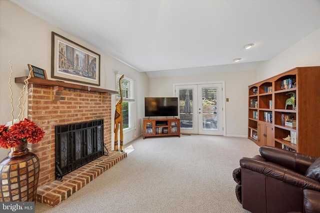 living area featuring baseboards, french doors, carpet, and a brick fireplace