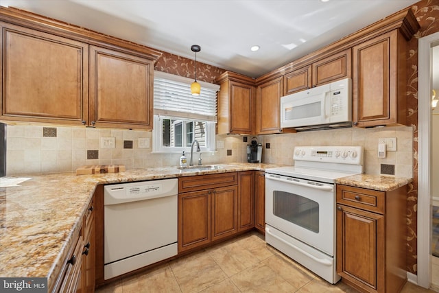 kitchen with a sink, tasteful backsplash, white appliances, and brown cabinets