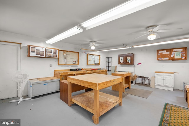 interior space featuring a workshop area, a ceiling fan, and finished concrete floors