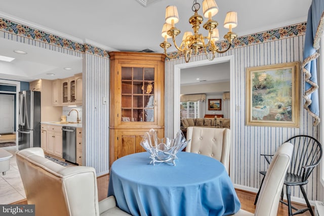 dining area with crown molding, a notable chandelier, and wallpapered walls