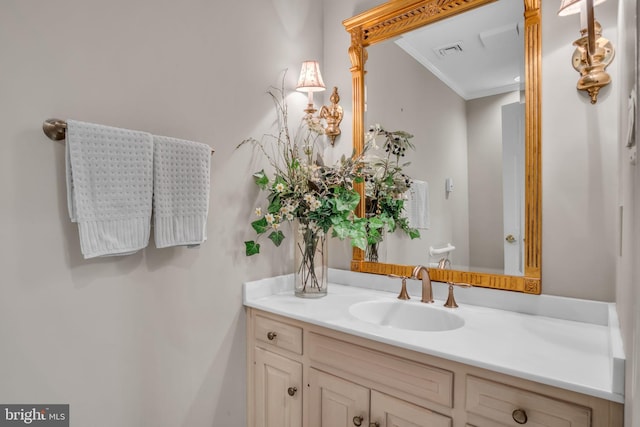 bathroom featuring visible vents, crown molding, and vanity