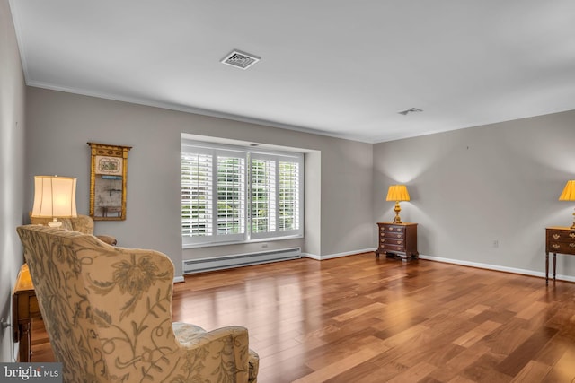 living area with crown molding, visible vents, baseboards, wood finished floors, and a baseboard heating unit