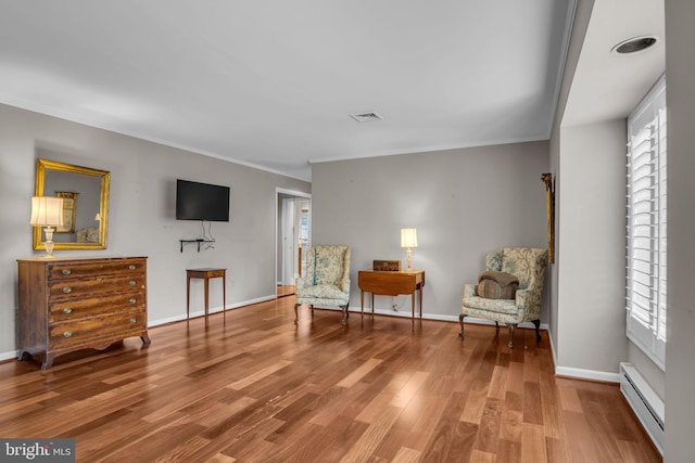 sitting room featuring ornamental molding, a wealth of natural light, and a baseboard radiator