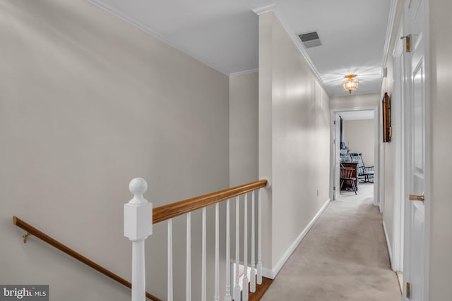 corridor featuring baseboards, ornamental molding, carpet floors, and an upstairs landing
