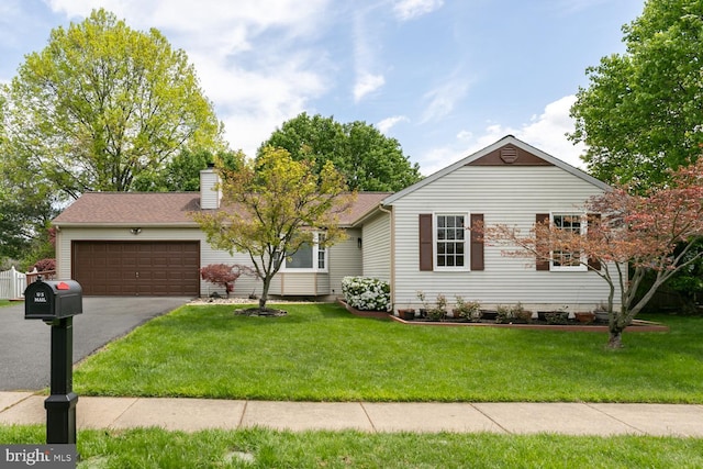 single story home with a front yard, a chimney, aphalt driveway, and an attached garage