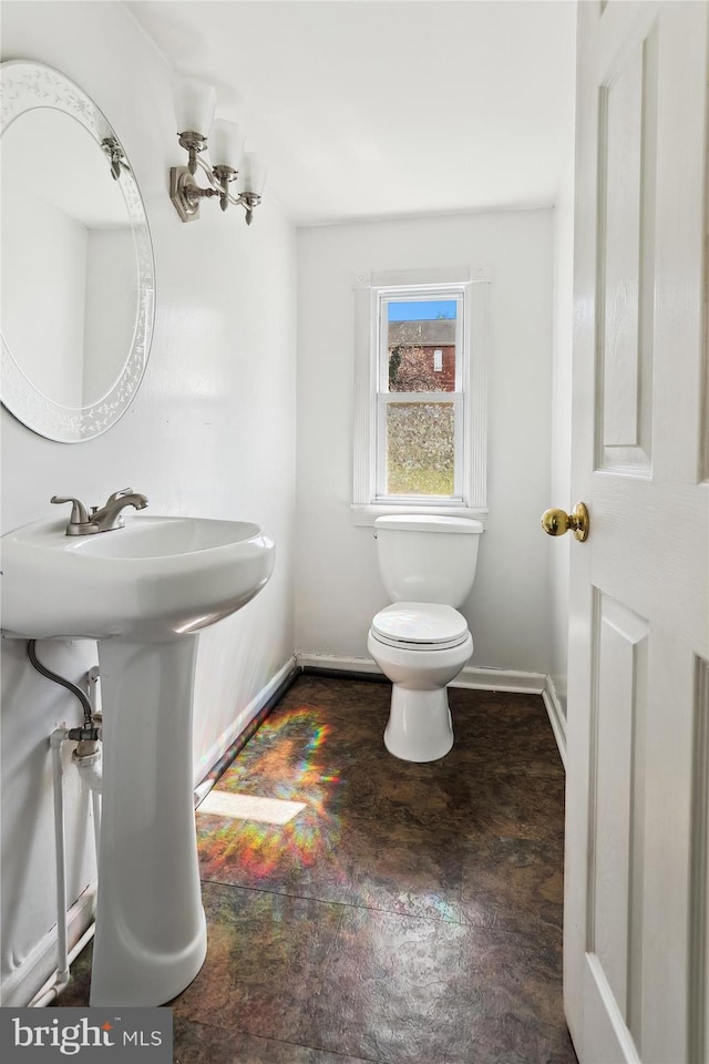 bathroom featuring baseboards and toilet
