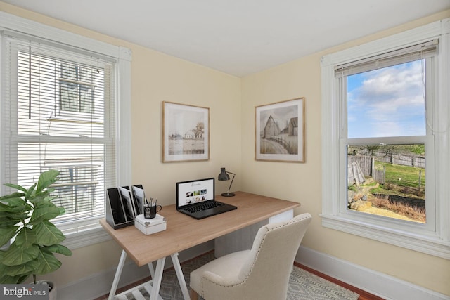 home office featuring baseboards, wood finished floors, and a wealth of natural light