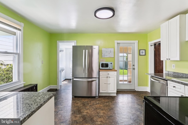 kitchen featuring a healthy amount of sunlight, white cabinets, and stainless steel appliances