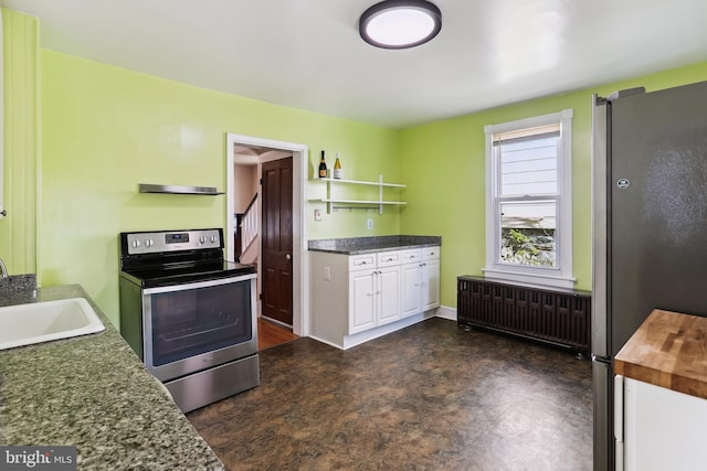 kitchen featuring radiator heating unit, white cabinetry, a sink, wood counters, and stainless steel appliances