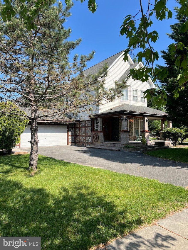 view of front facade featuring a garage, driveway, and a front lawn