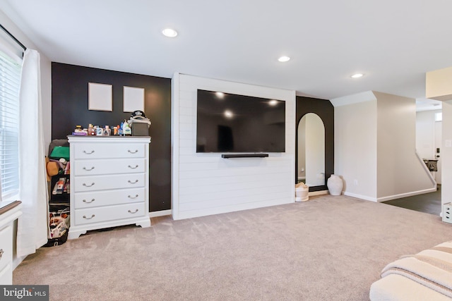 carpeted living room with recessed lighting, arched walkways, and baseboards