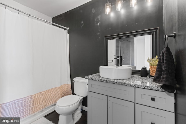 bathroom featuring toilet, curtained shower, vanity, and baseboards