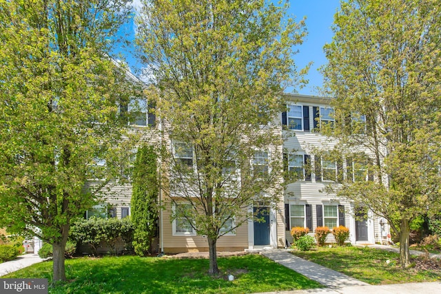 townhome / multi-family property with a front lawn