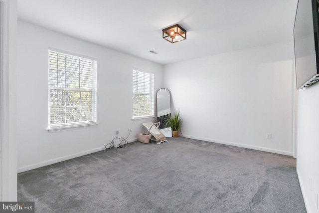 carpeted spare room with baseboards and visible vents