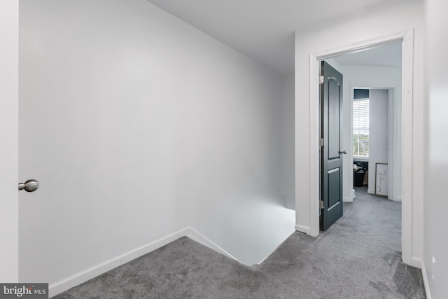 corridor featuring carpet floors and baseboards