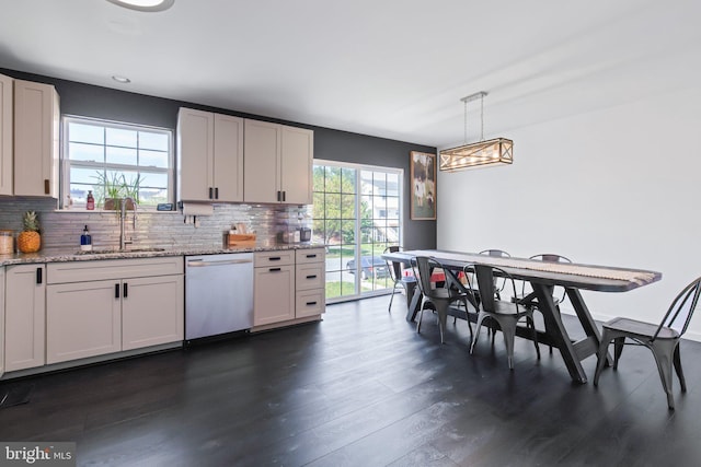 kitchen featuring stainless steel dishwasher, dark wood-style flooring, backsplash, and a sink