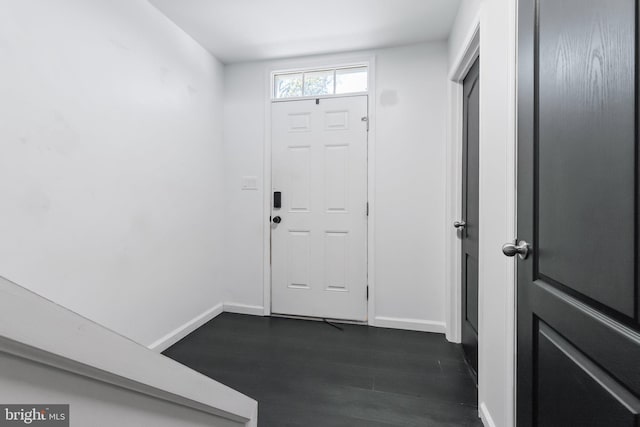foyer entrance featuring baseboards and dark wood finished floors