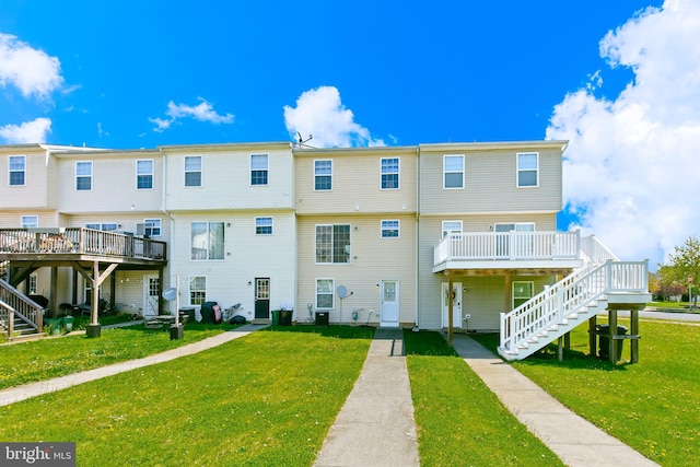 rear view of property featuring stairs, a yard, and a wooden deck