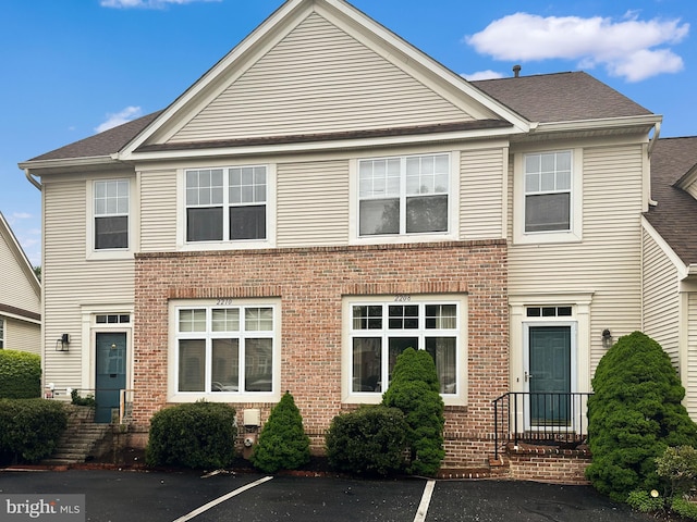 2208 Merion Pond Pond Unit 62, Woodstock, MD 21163 - view of property featuring roof with shingles, uncovered parking, and brick siding