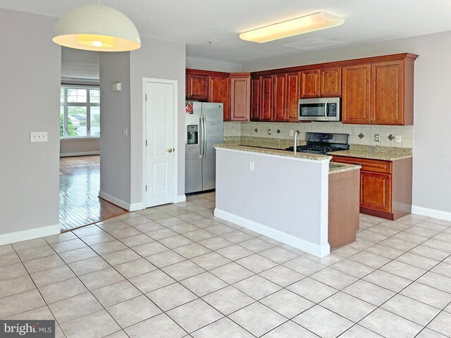 2208 Merion Pond Pond Unit 62, Woodstock, MD 21163 - kitchen featuring light stone counters, stainless steel appliances, baseboards, tasteful backsplash, and a center island with sink