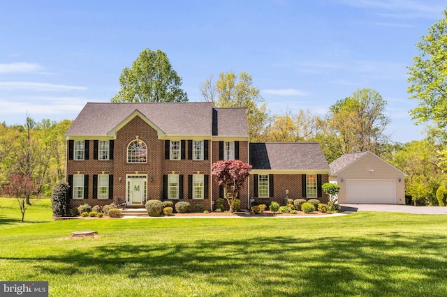 colonial-style house featuring brick siding, a front lawn, and driveway