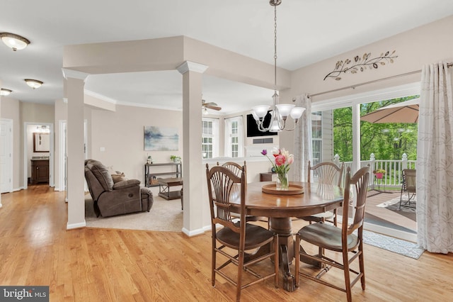 dining room featuring light wood-type flooring, ornamental molding, baseboards, and a notable chandelier