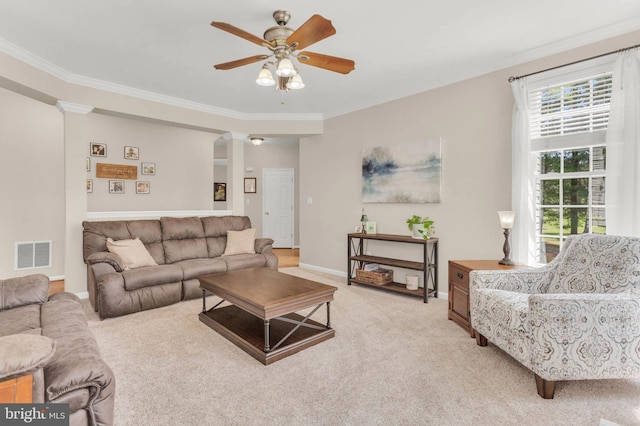living room featuring a ceiling fan, visible vents, crown molding, baseboards, and light carpet