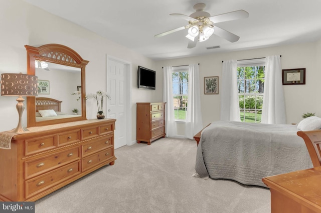 bedroom featuring visible vents, ceiling fan, and light carpet