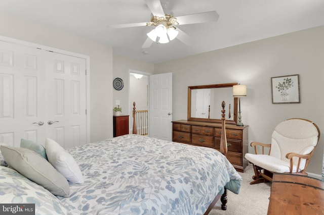 bedroom featuring a ceiling fan, light carpet, and a closet