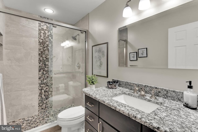 full bath featuring vanity, a stall shower, and toilet