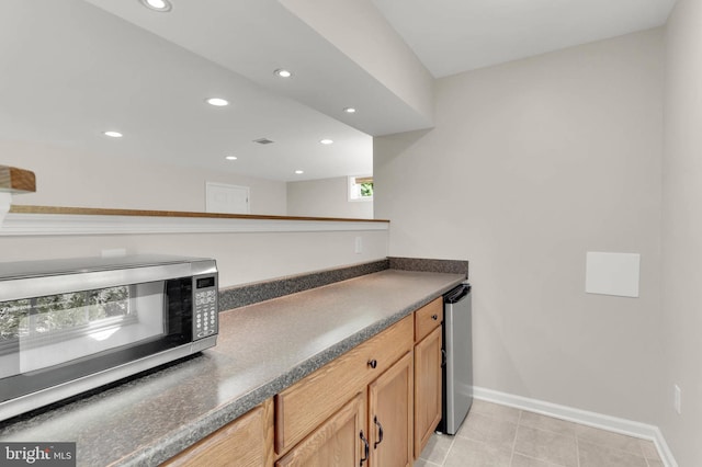 bar featuring recessed lighting, stainless steel microwave, light tile patterned floors, and baseboards