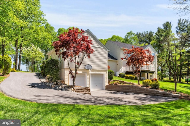 view of front of house with concrete driveway, an attached garage, and a front yard