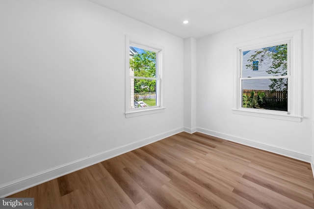 unfurnished room featuring baseboards, recessed lighting, and wood finished floors