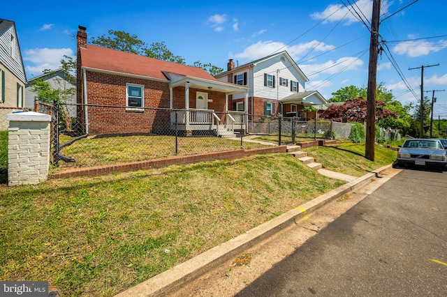 view of front facade with brick siding, fence, and a front lawn
