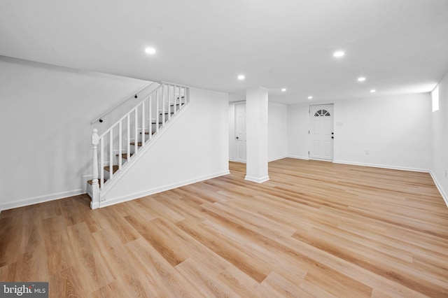 below grade area with recessed lighting, light wood-style flooring, stairs, and baseboards