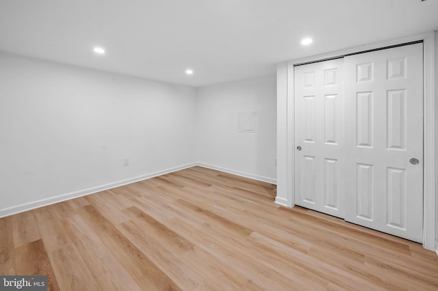 unfurnished bedroom with recessed lighting, light wood finished floors, baseboards, and a closet