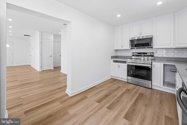 kitchen with white cabinets, stainless steel appliances, backsplash, and light wood-style floors
