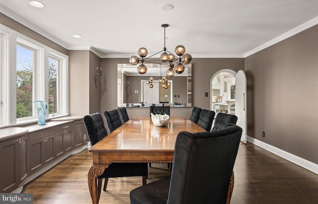 dining area with crown molding, arched walkways, dark wood-style floors, and a chandelier