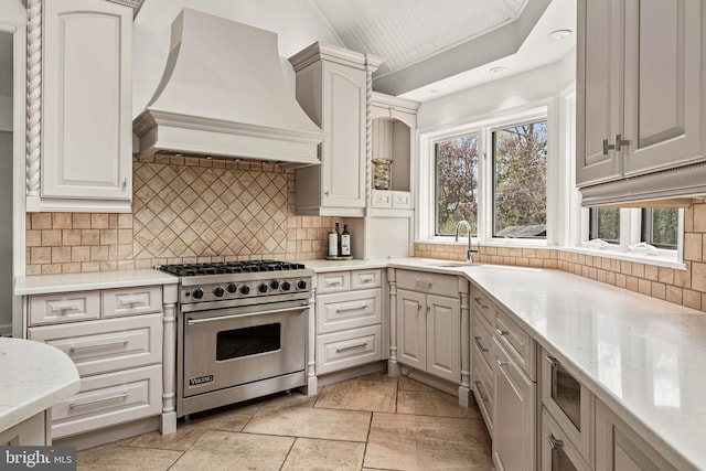kitchen with backsplash, a sink, custom exhaust hood, recessed lighting, and luxury range