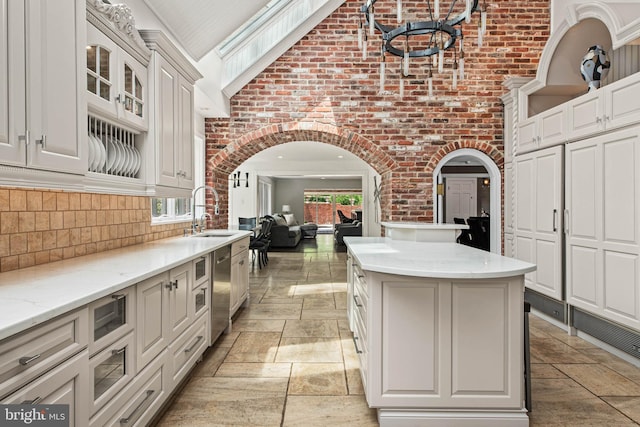 kitchen with a sink, a center island, a wealth of natural light, and dishwasher