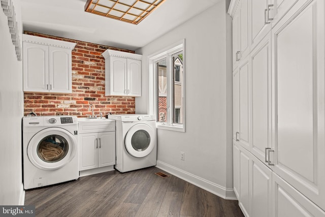 clothes washing area with baseboards, cabinet space, dark wood-type flooring, and a healthy amount of sunlight