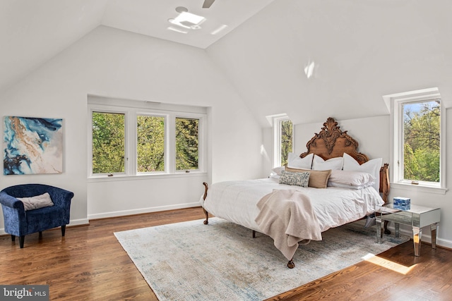 bedroom featuring wood finished floors, baseboards, ceiling fan, and lofted ceiling
