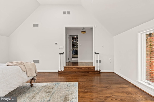 bedroom with visible vents, wood finished floors, and vaulted ceiling