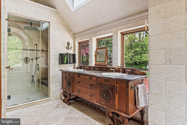 full bath with a sink, lofted ceiling with skylight, and a stall shower