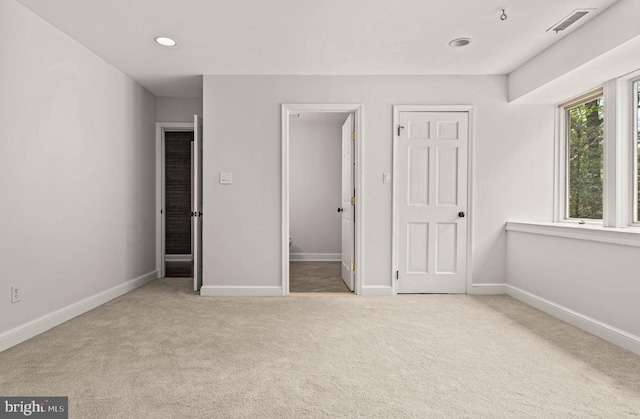unfurnished bedroom featuring baseboards, carpet flooring, recessed lighting, and visible vents