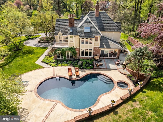 view of swimming pool featuring a yard, a patio, a pool with connected hot tub, and fence