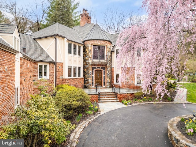 view of front facade with a chimney and stucco siding